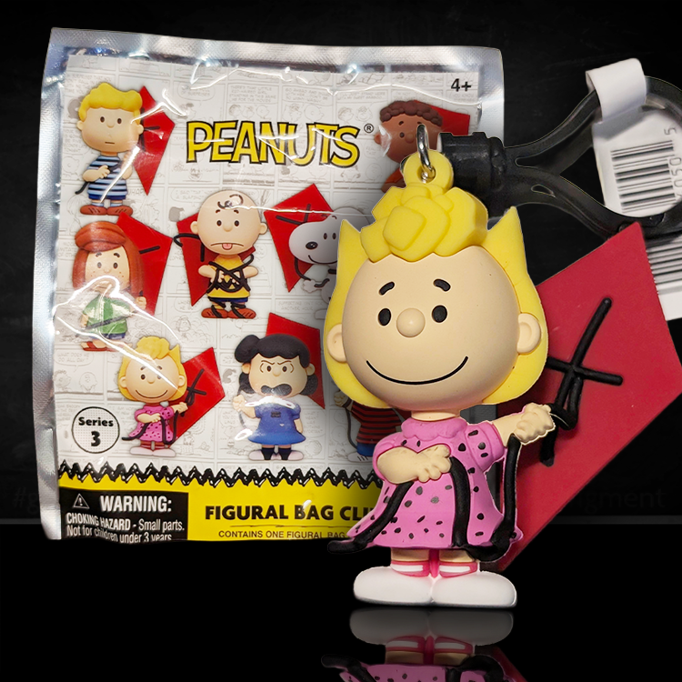 Sally Brown figure bag clip by Monogram from Peanuts 75th Anniversary Series 3 holding a red kite and wearing pink dress.