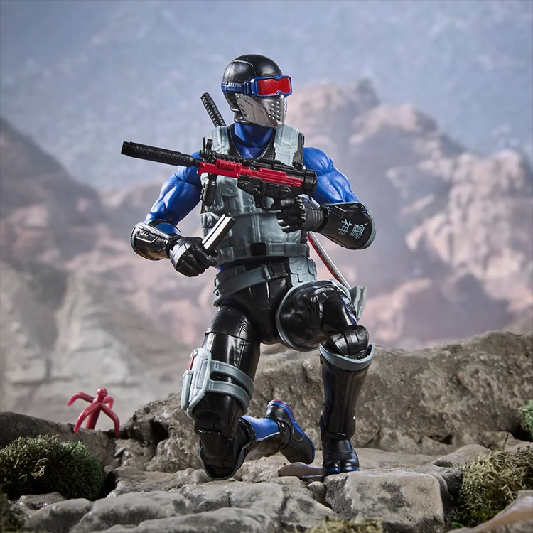 Hasbro G.I. Joe Snake Eyes action figure kneeling with sword and red gun in rocky desert terrain background.