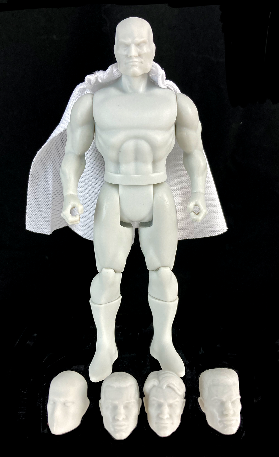Boss Fight Studio Llc 5-inch blank retro-style action figure with white cape and four interchangeable heads on black background