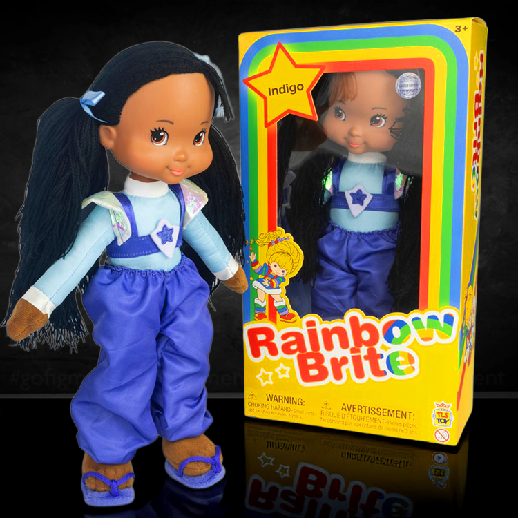 Rainbow Brite Indigo plush doll standing beside its colorful SDCC 2025 exclusive box by The Loyal Subjects