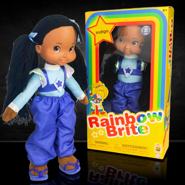 Rainbow Brite Indigo plush doll standing beside its colorful SDCC 2025 exclusive box by The Loyal Subjects