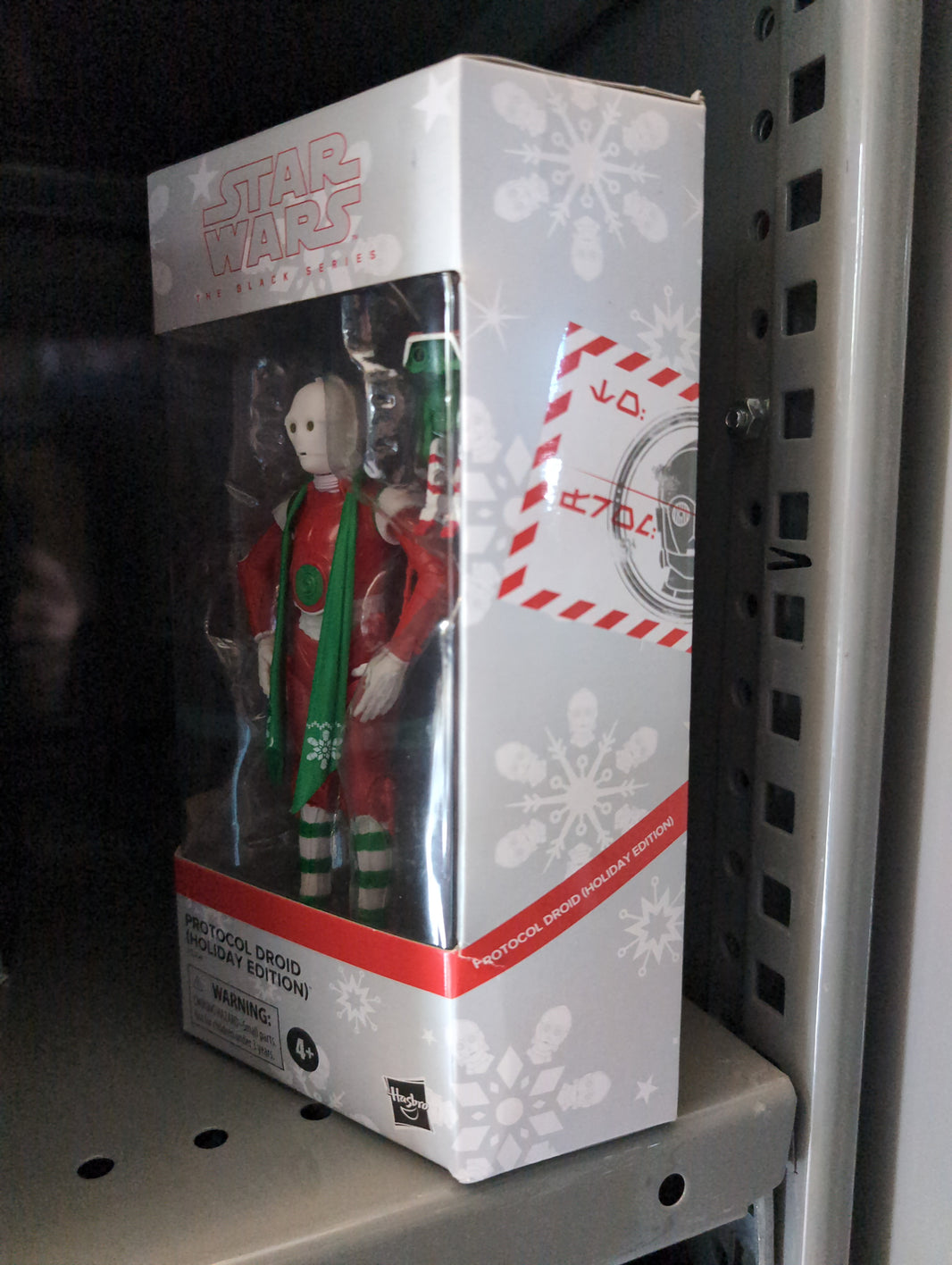 Hasbro Star Wars Black Series Christmas Protocol Droid action figure in festive holiday packaging on store shelf.