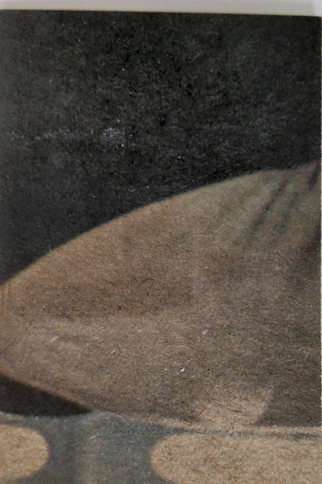 Close-up of textured fabric with soft folds in muted brown and dark gray tones background