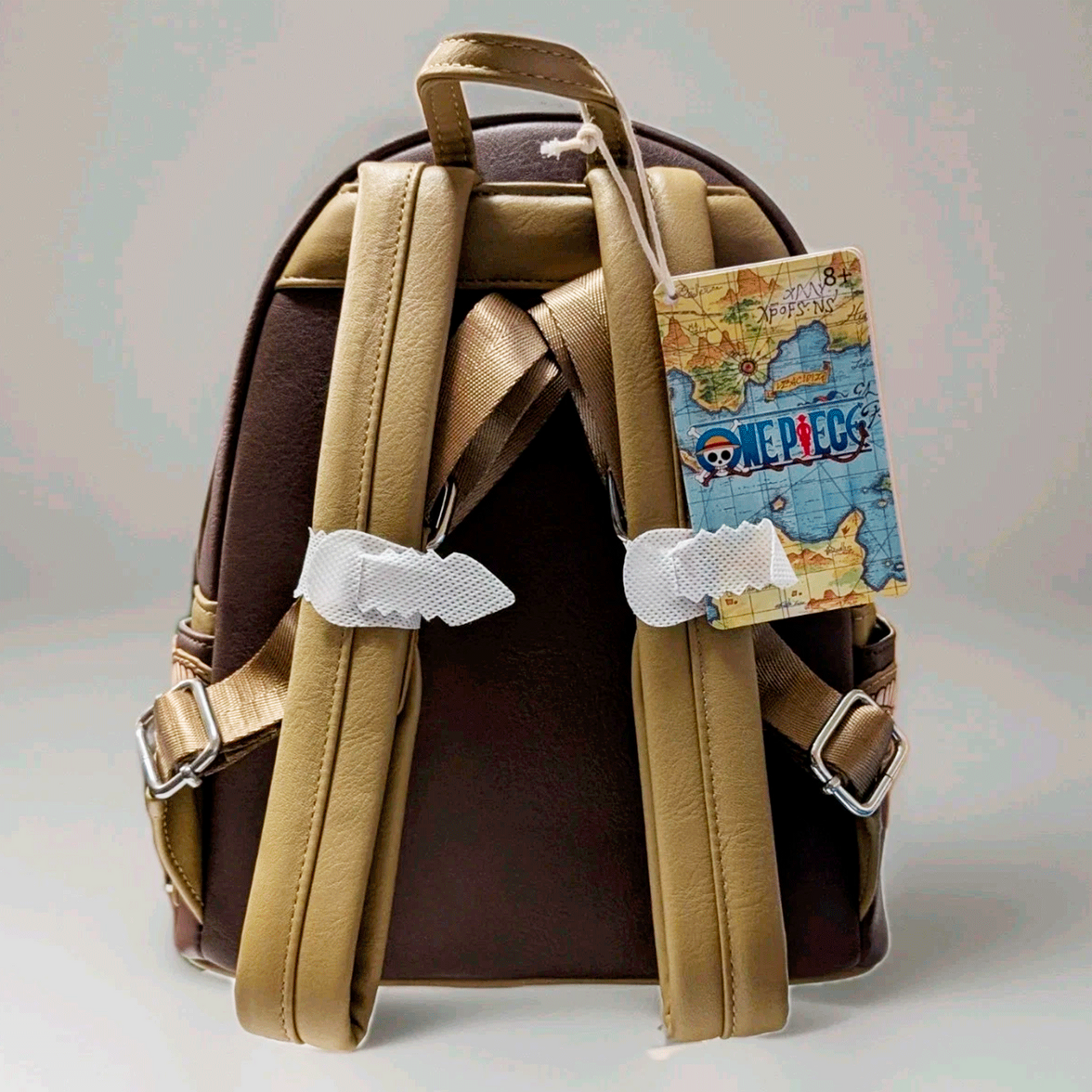Back view of Loungefly mini backpack with tan straps and One Piece map design tag on brown faux leather