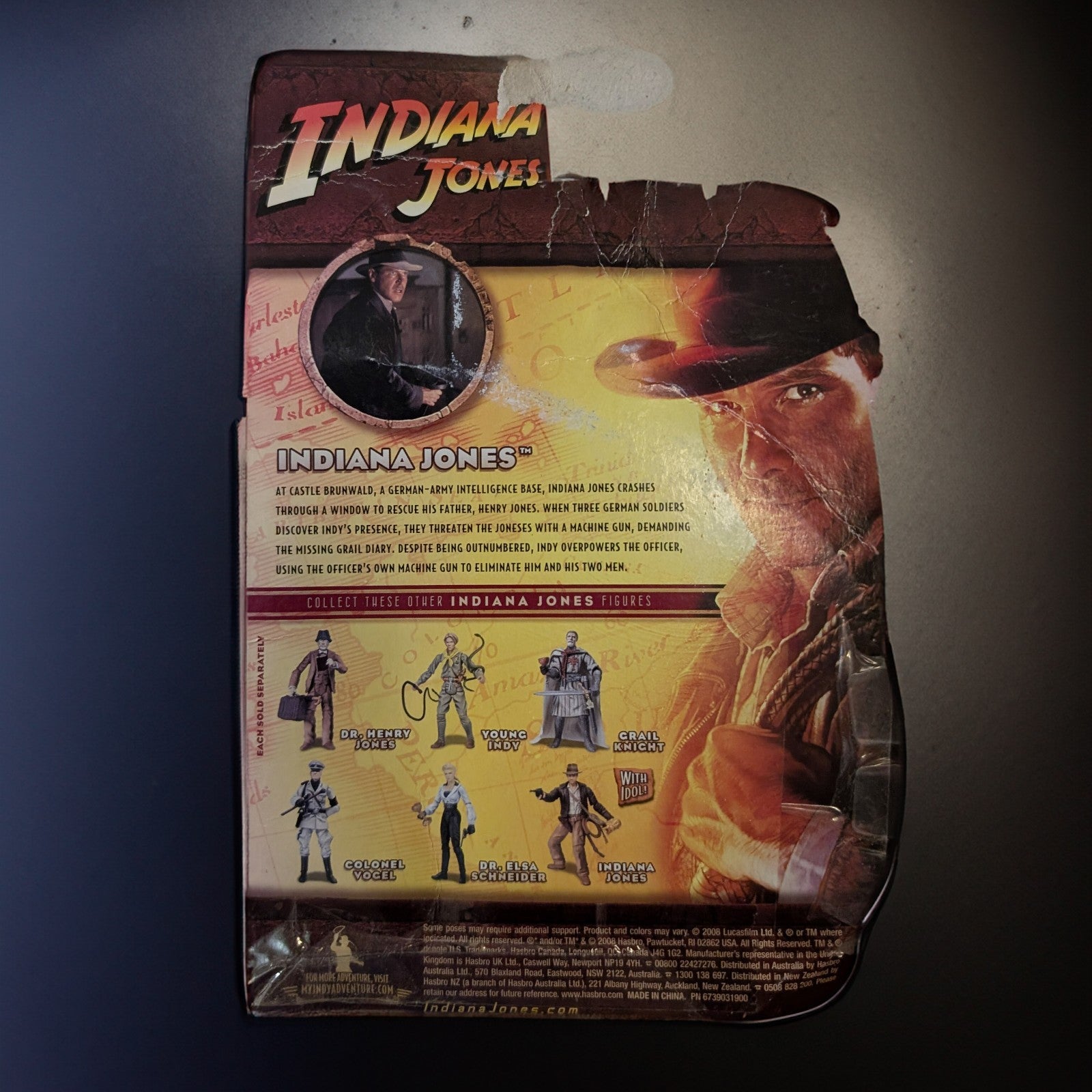 Hasbro Indiana Jones Last Crusade 2008 action figure packaging with character images and vintage movie art background