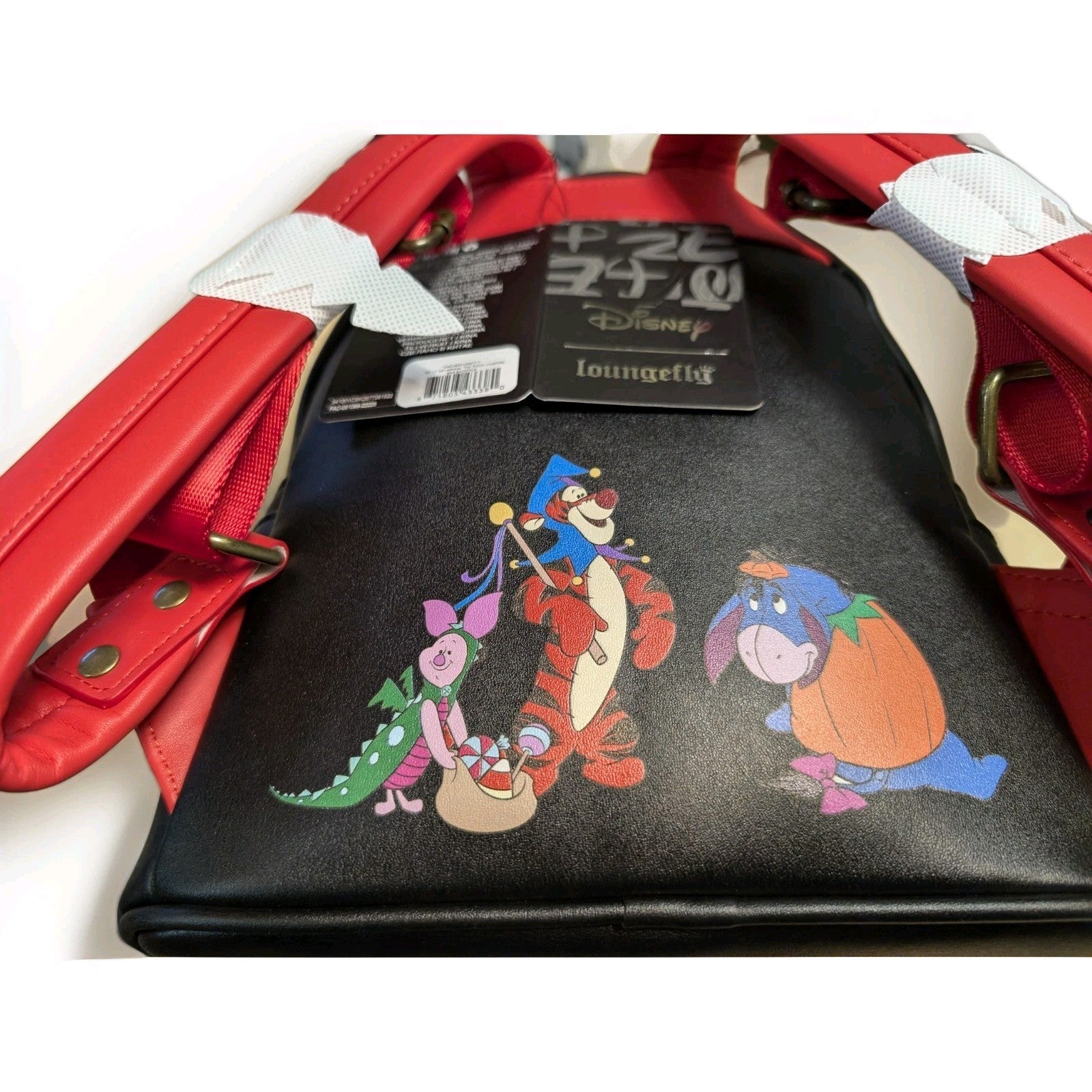 Loungefly black mini backpack with Halloween costumed Winnie the Pooh characters and red faux leather straps detail