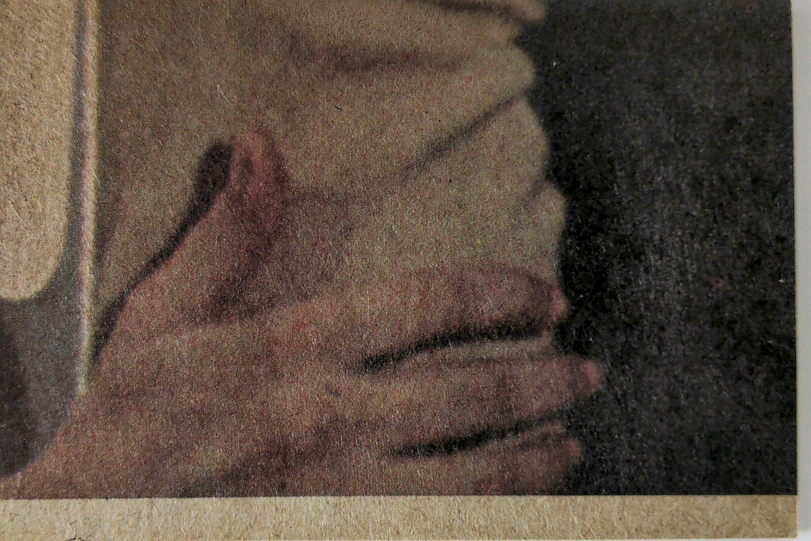Close-up of hands gently clasping a textured surface with muted, earthy tones and soft shadows