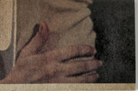 Close-up of hands gently clasping a textured surface with muted, earthy tones and soft shadows