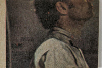 Close-up of vintage book cover featuring a man in profile wearing a white shirt against dark background