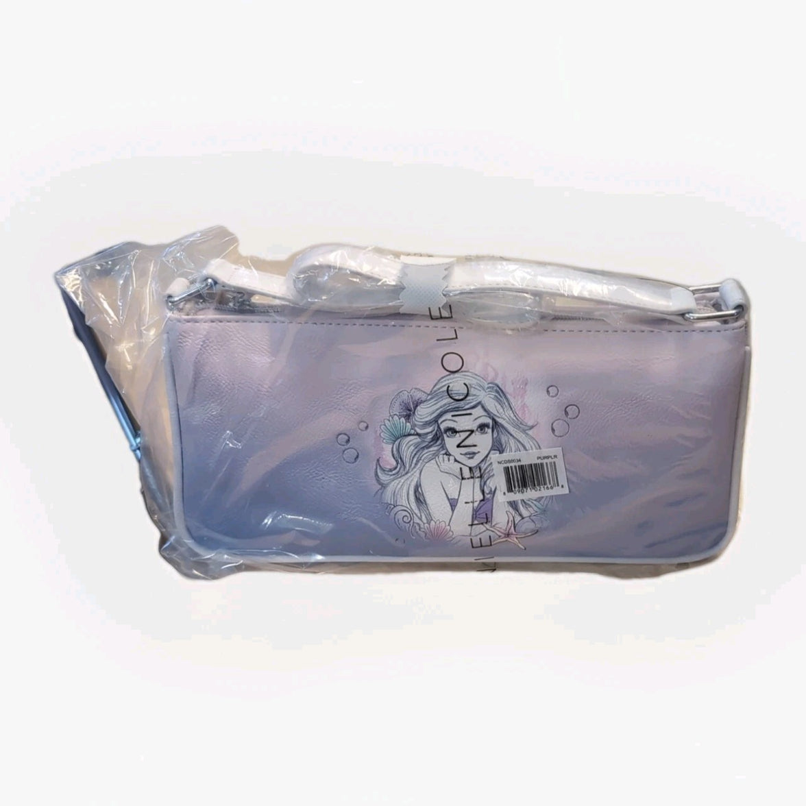 Danielle Nicole pastel purple baguette bag with Ariel illustration in protective plastic wrap and barcode label visible
