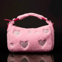 Loungefly pink sherpa crossbody bag with heart cutouts and plush handle against black background
