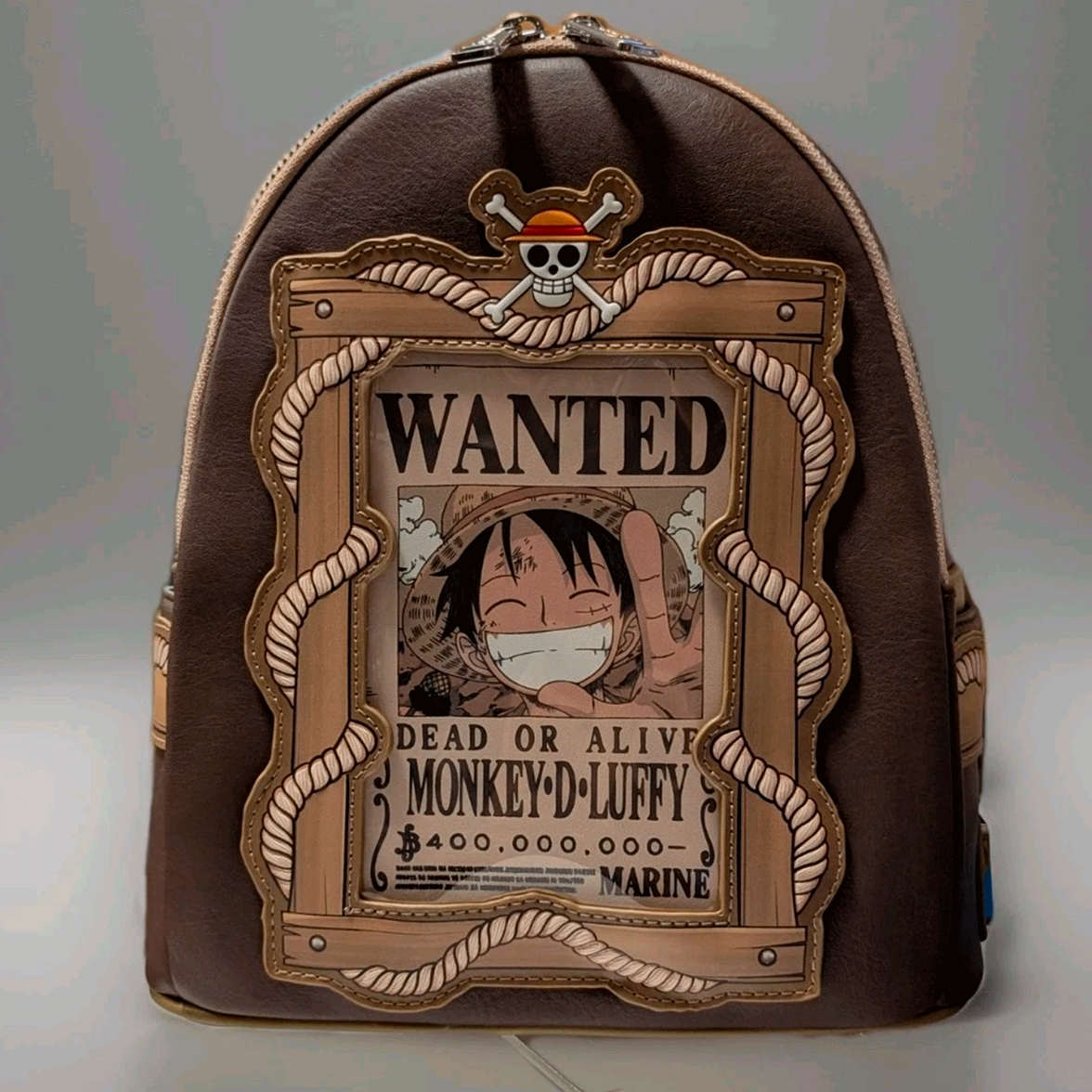 Front view of Loungefly mini backpack with Monkey D. Luffy wanted poster and rope detailing on brown faux leather
