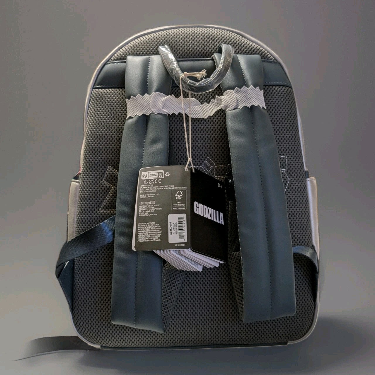 Back view of Loungefly Godzilla Mechagodzilla full-size backpack with padded straps and attached product tags visible