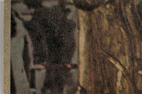 Close-up image showing worn and textured surface with muted brown and gray tones on vintage item