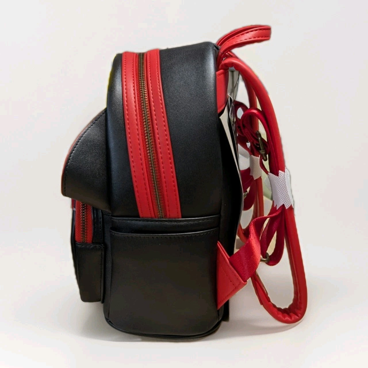 Loungefly mini backpack side view showing black and red faux leather with adjustable straps and zipper details