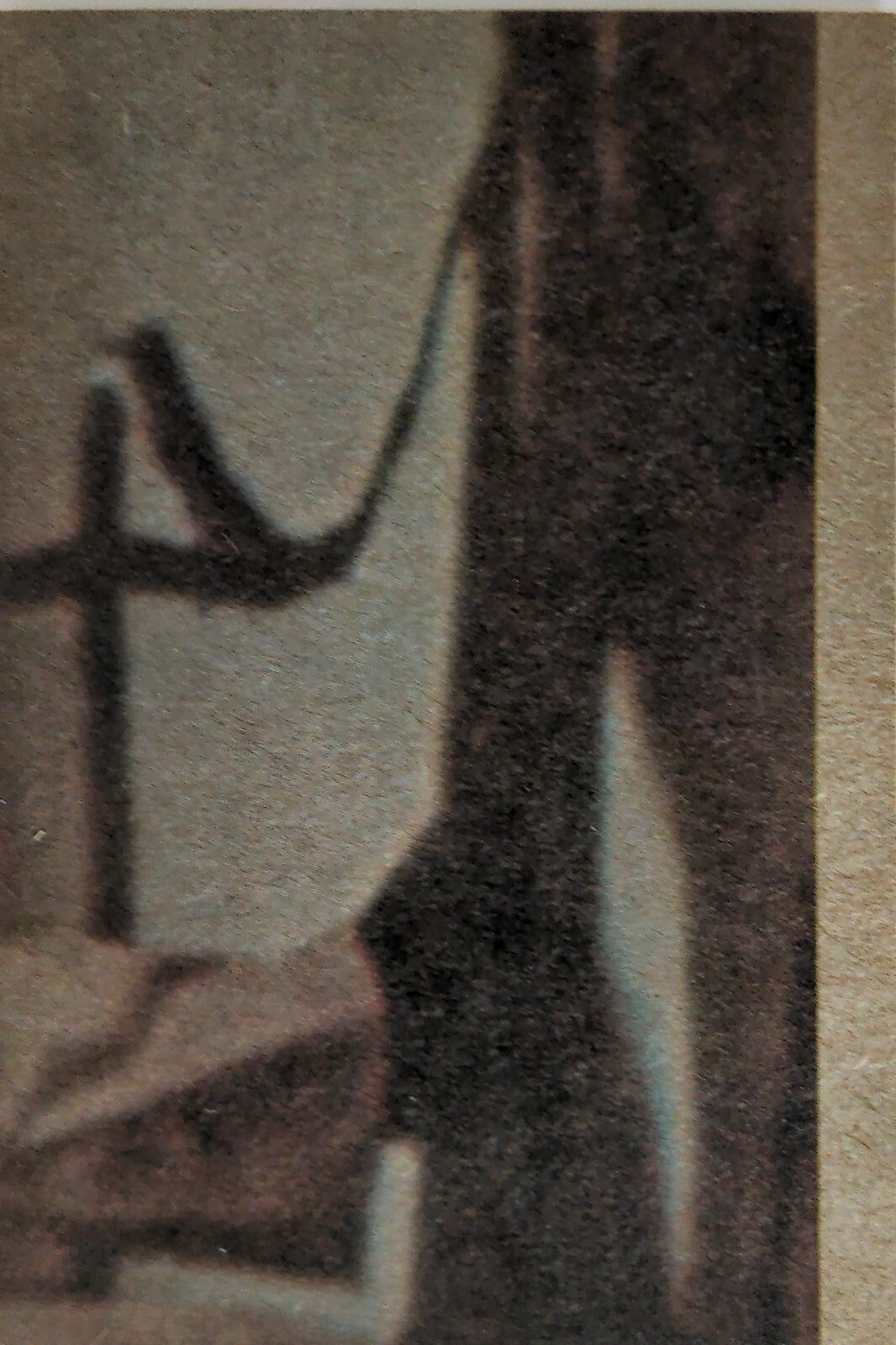 Close-up of vintage textured material showing dark and light abstract shapes and a faint wire pattern on beige background