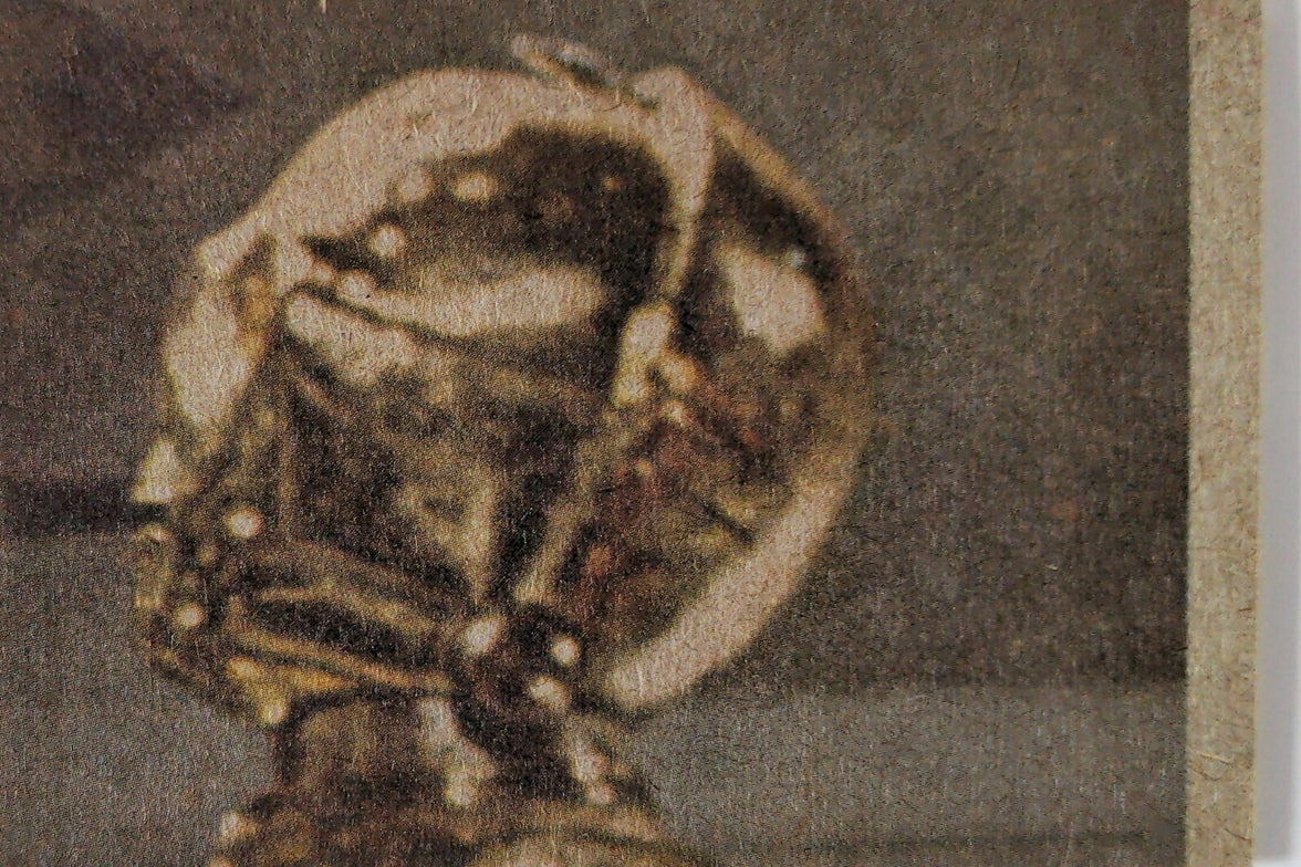 Close-up view of vintage Hardy Boys book cover showing globe and magnifying glass illustration details