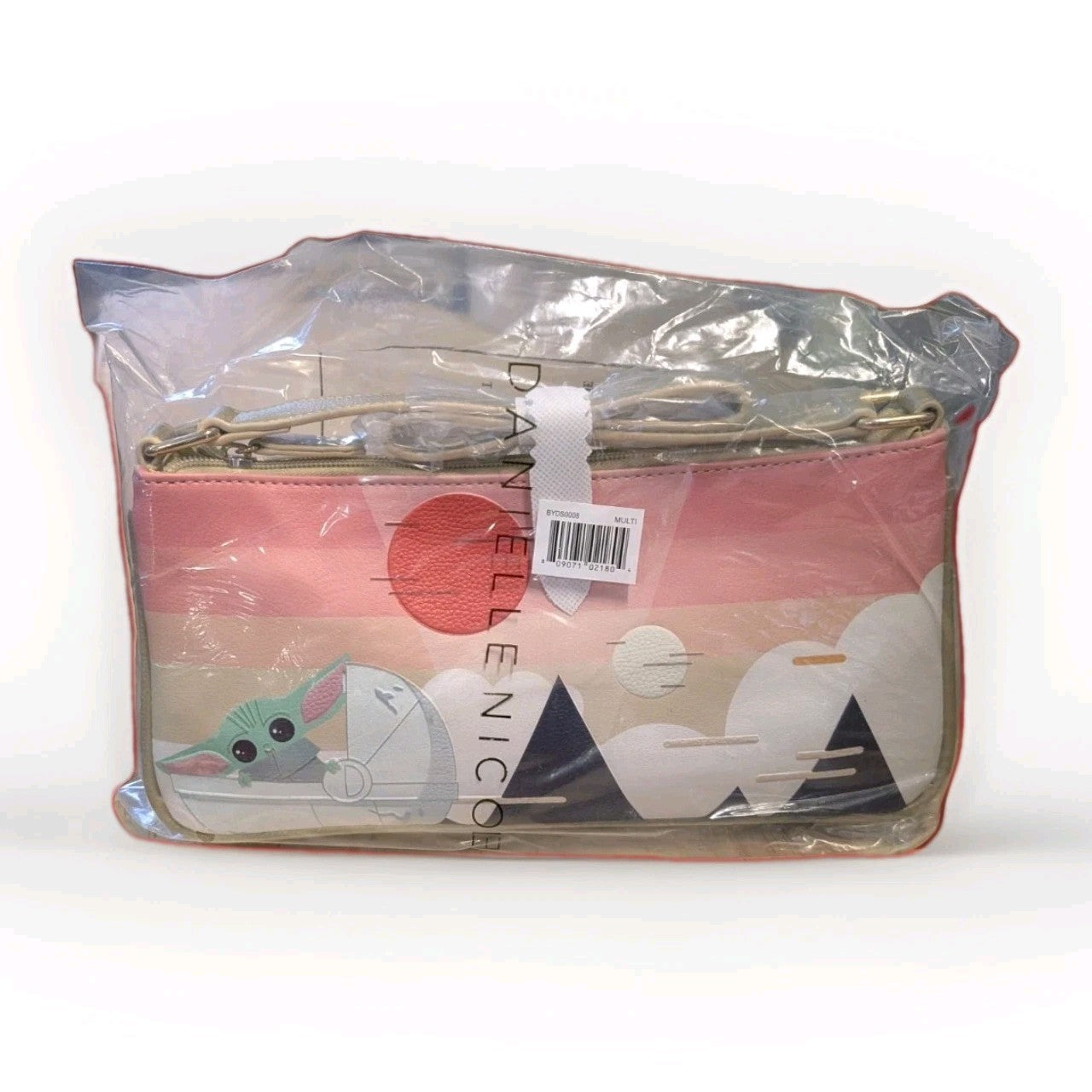 Danielle Nicole crossbody bag featuring Grogu in a stylized landscape with pink and beige tones in clear packaging
