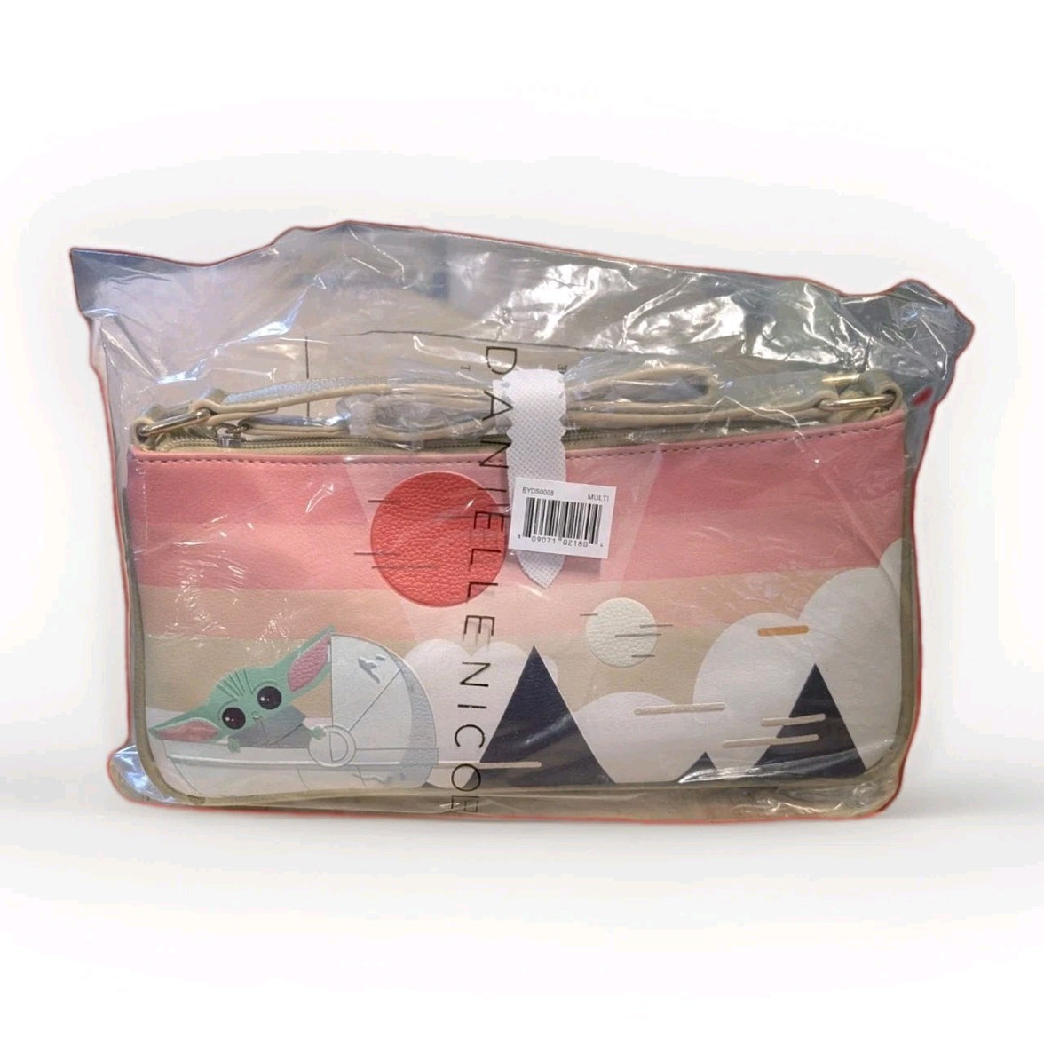 Danielle Nicole crossbody bag featuring Grogu in a stylized landscape with pink and beige tones in clear packaging