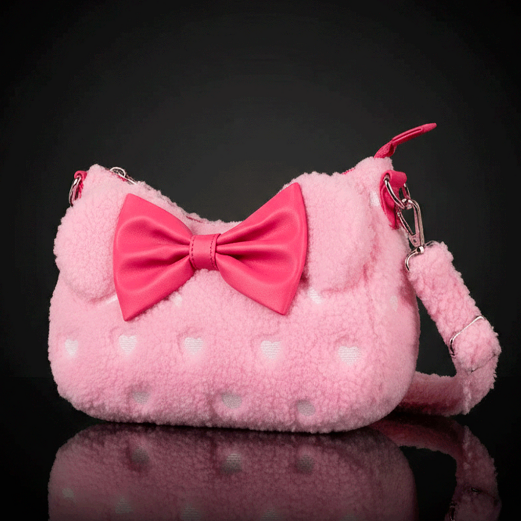 Loungefly pink sherpa crossbody bag with heart patterns and large satin bow detail on front against black background