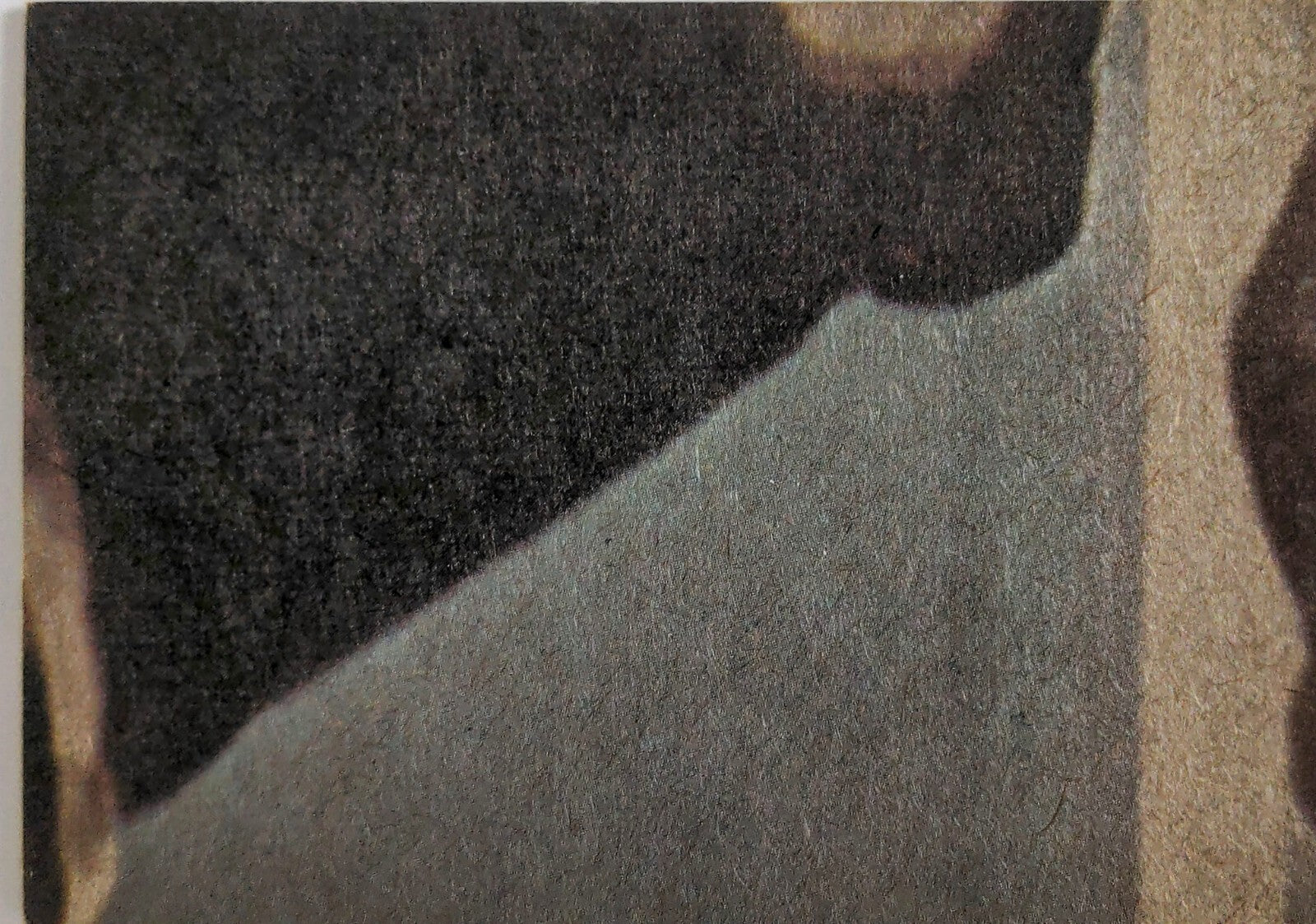 Close-up of textured fabric showing dark and light color contrast with visible fibers and stitching details