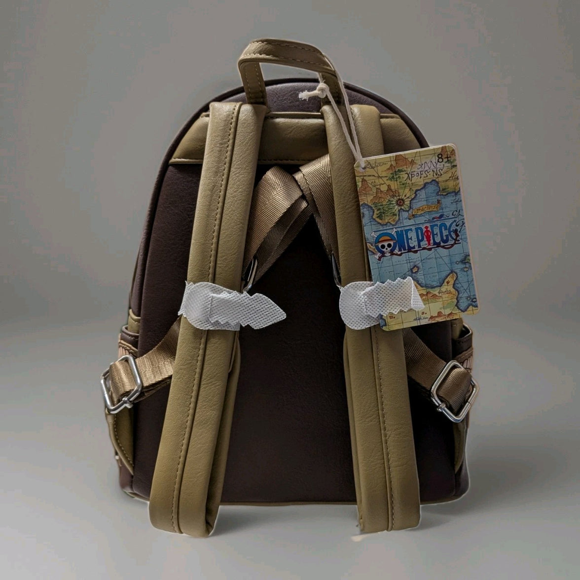 Back of Loungefly mini backpack with adjustable tan straps and One Piece map design tag on brown faux leather