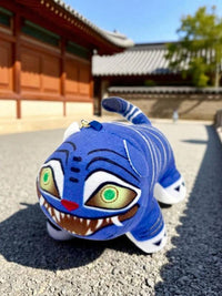 K-Wonderland K-Pop Hunters plush tiger keyring in bright blue with bold stripes and vivid embroidered eyes outdoors