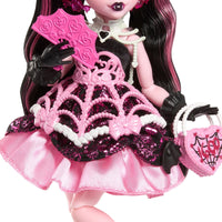 Monster High Draculaura doll in pink black spiderweb dress holding heart-shaped purse and fan by Mattel