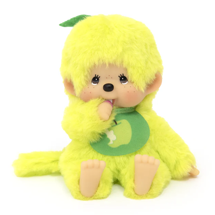 Sekiguchi Monchhichi plush in bright apple green with soft fur, plastic face, hands, and feet, wearing an apple bib.