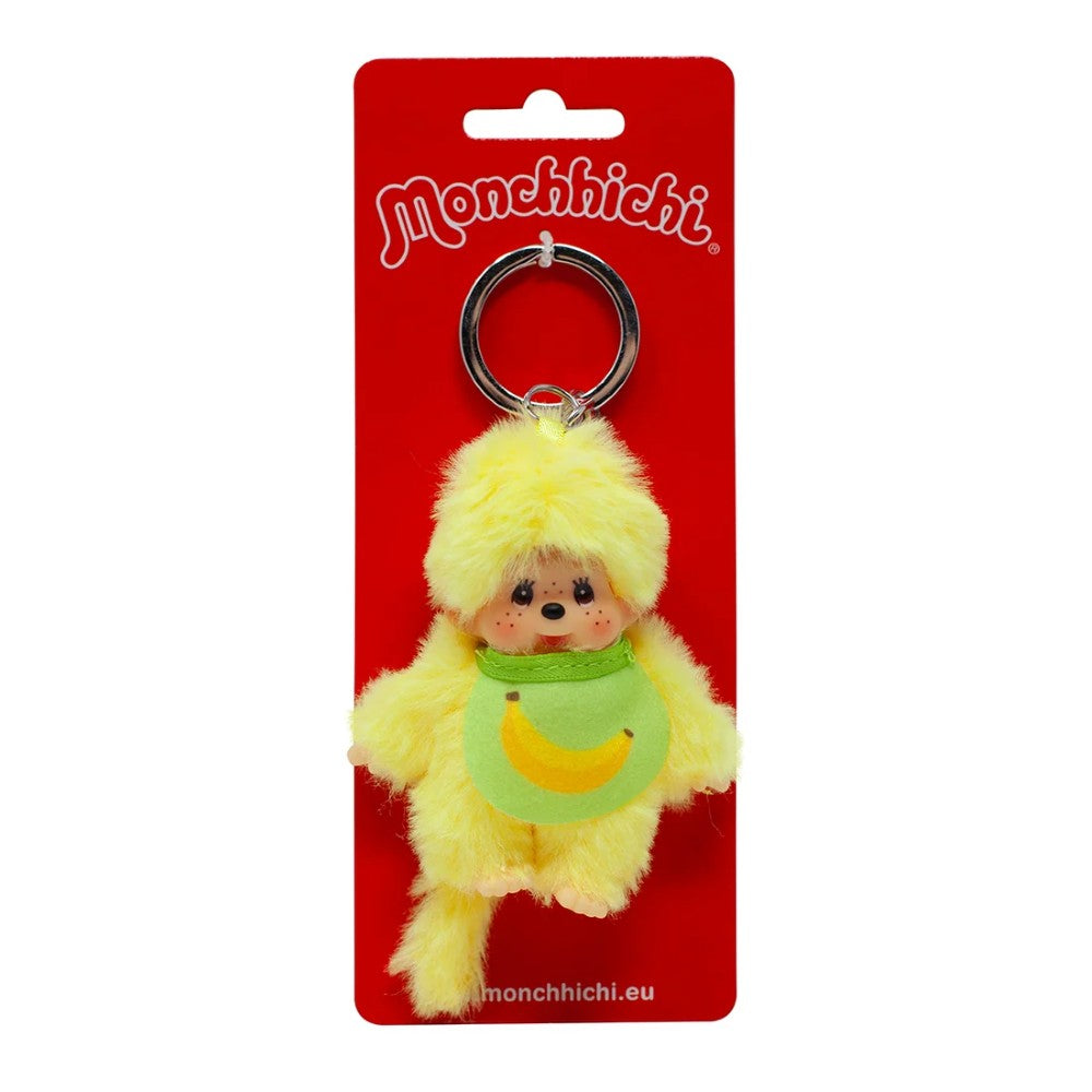 Yellow Monchhichi plush keychain with green bib on a red backing card