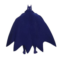 Back view of a small figure with pointed ears and a dark blue bat-shaped cape