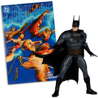 Batman action figure posed beside a Justice comic book cover featuring multiple superheroes in dynamic poses.