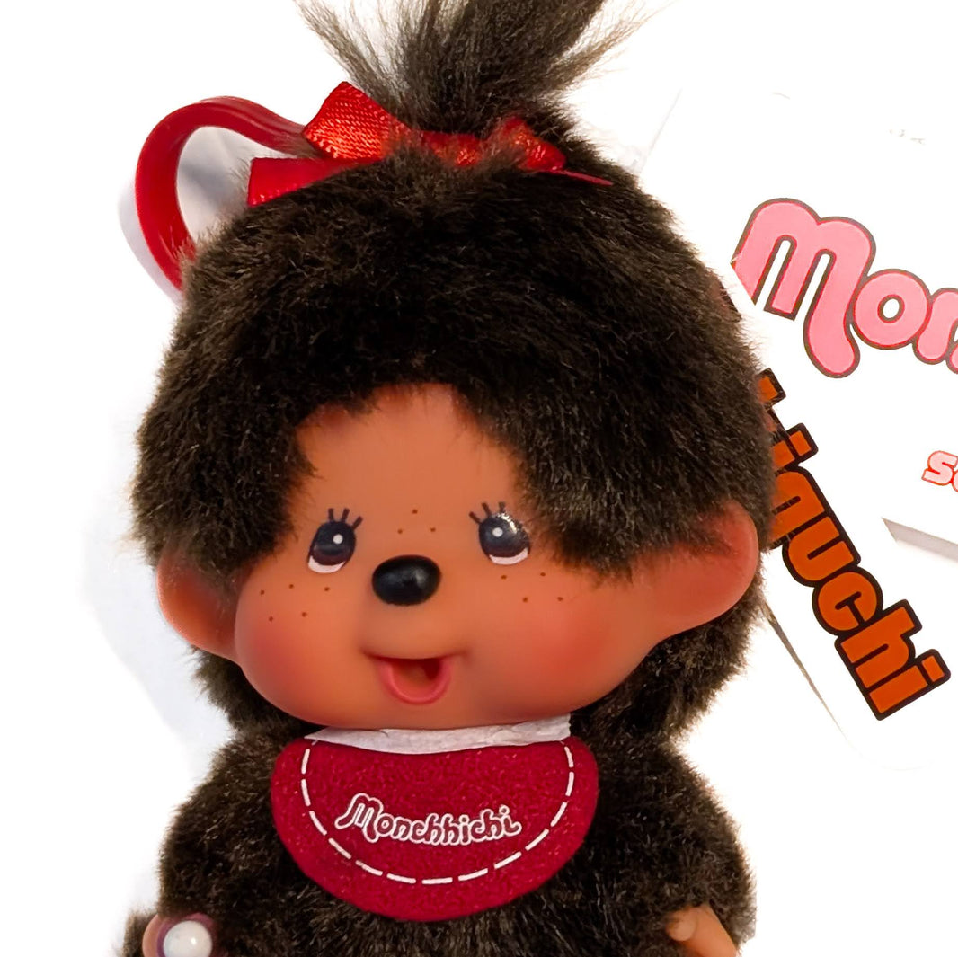 Sekiguchi Monchhichi Classic Big Head Girl Plush 4-inch mascot clip with red bib and smiling face close-up