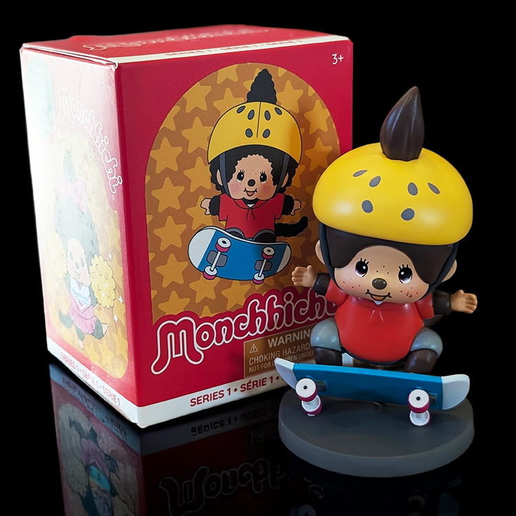 Sekiguchi Monchhichi Boy Skateboarder vinyl figure in yellow helmet with blue skateboard on gray display stand