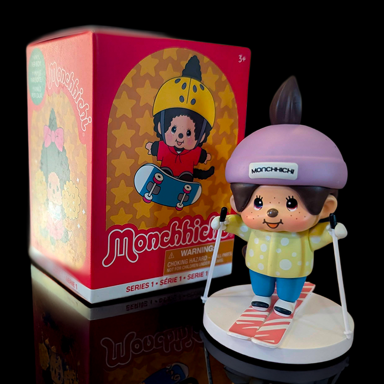 Sekiguchi Boy Monchhichi vinyl figure in skiing outfit with purple helmet and yellow jacket on snowy base