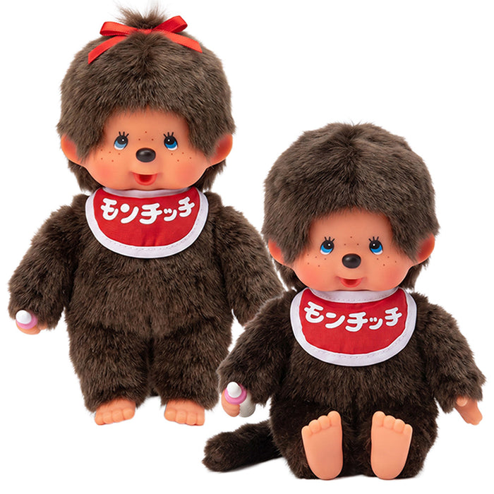 Two brown Monchhichi dolls with red Japanese character bibs, one wearing a red hair bow