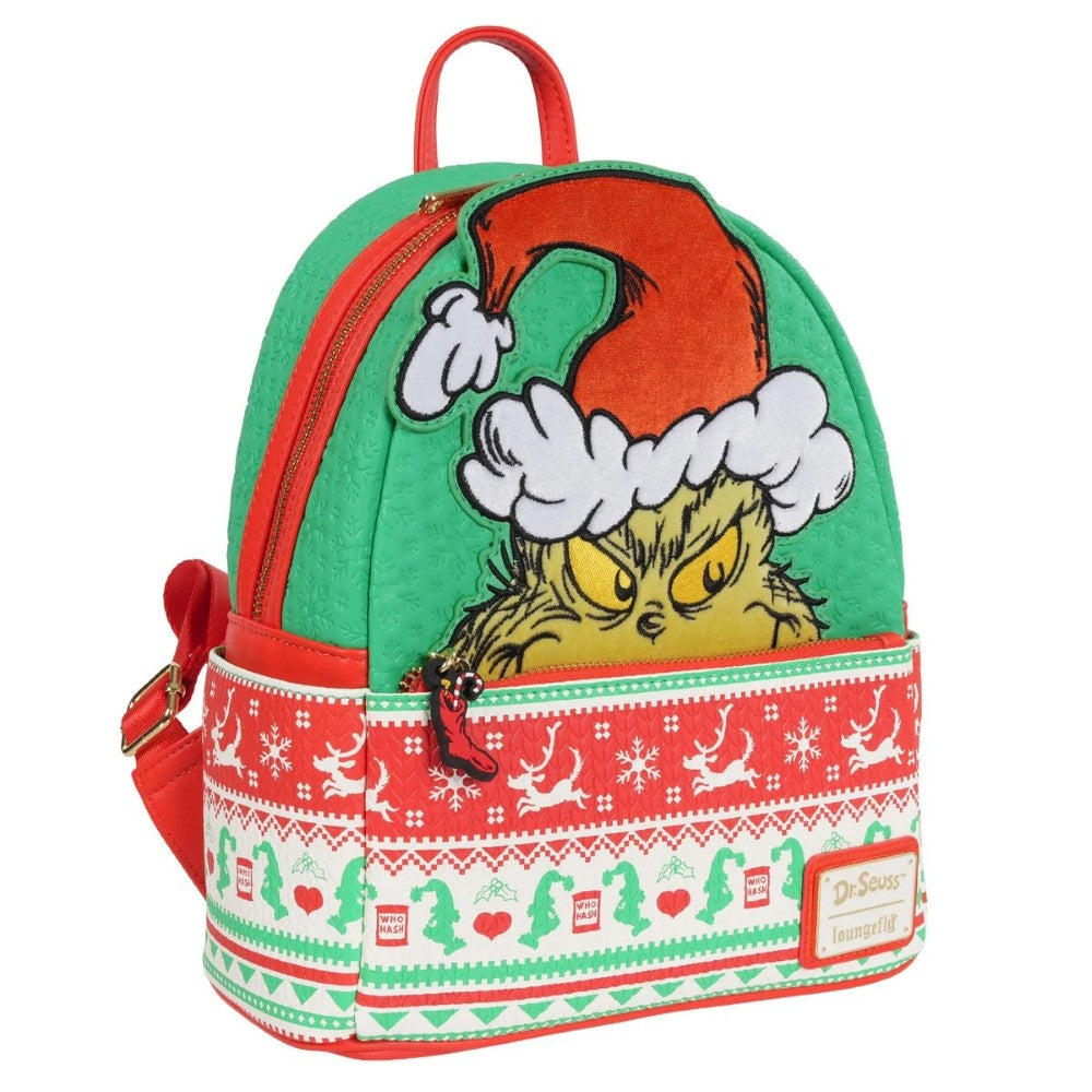 Loungefly mini-backpack with Grinch face wearing Santa hat and red and white holiday sweater pattern on green background