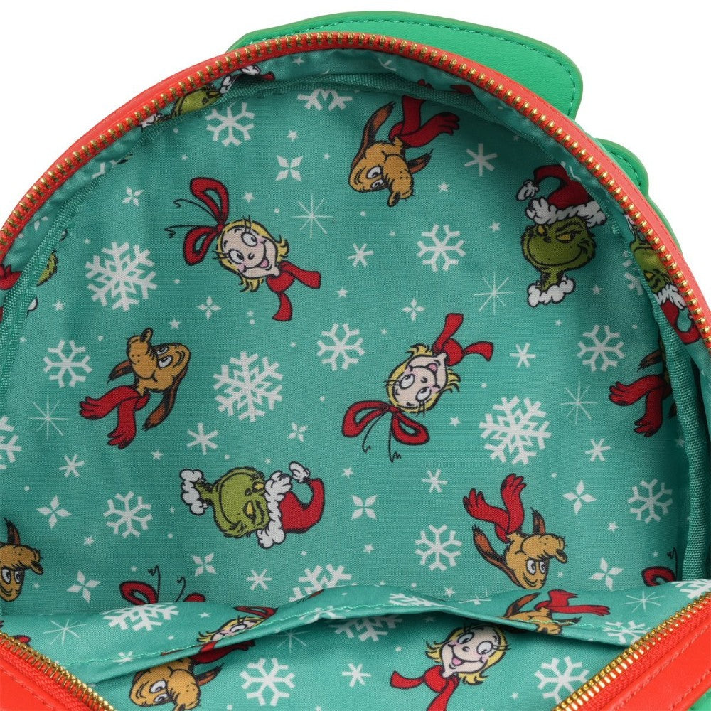 Interior lining of Loungefly Grinch mini-backpack featuring Grinch, Max, Cindy Lou Who, and white snowflake pattern
