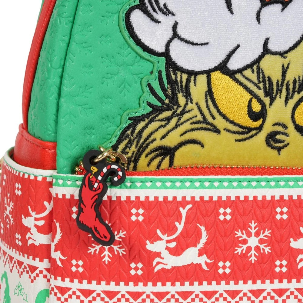Close-up of Loungefly Grinch mini-backpack showing festive red and white holiday knit pattern with reindeer and snowflakes