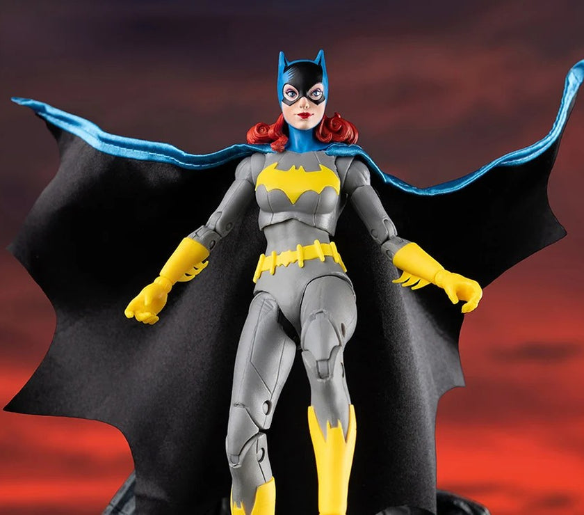 McFarlane DC Multiverse Batgirl action figure with cape in classic grey yellow costume against dark background