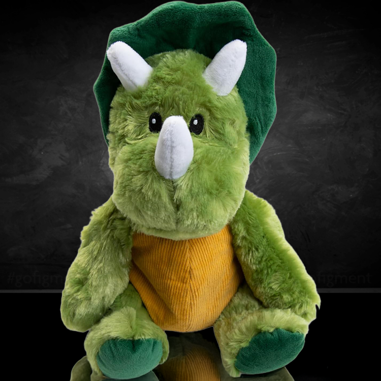 Green plush dinosaur toy with horns and yellow belly from Go Figment against dark background