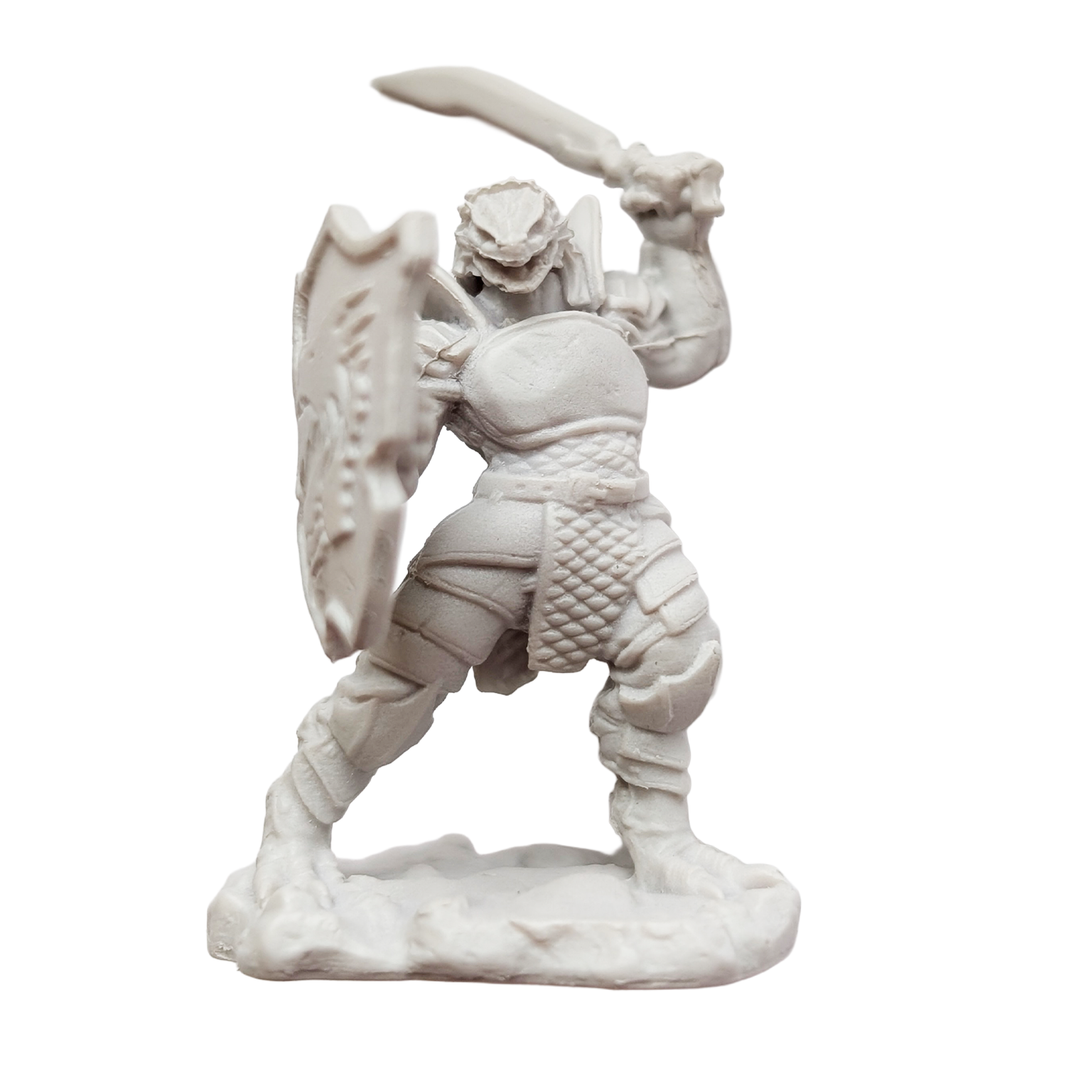 Unpainted fantasy warrior figurine holding a sword and shield on a textured base
