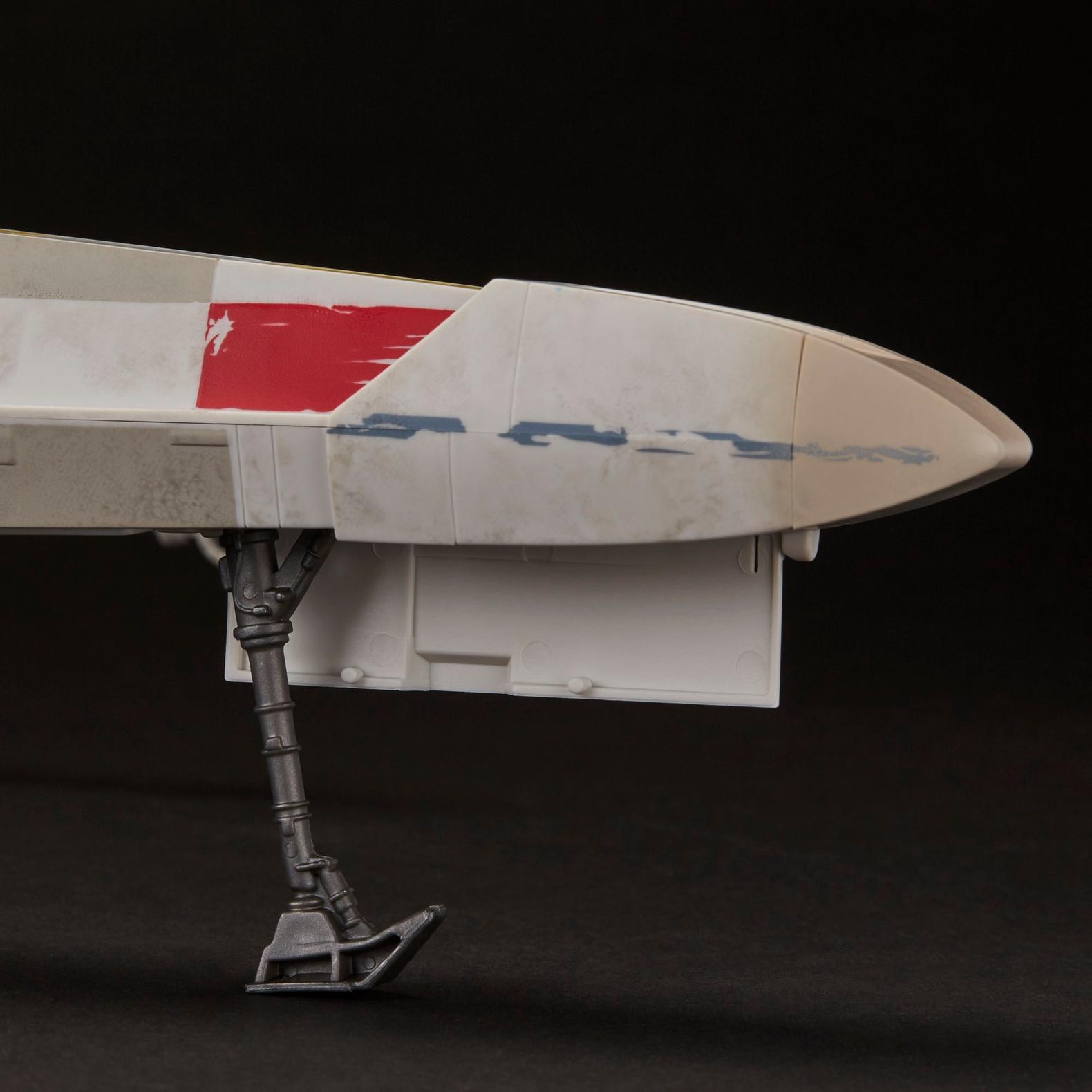 Close-up of weathered red and white X-Wing fighter landing gear with Kenner vintage style detailing