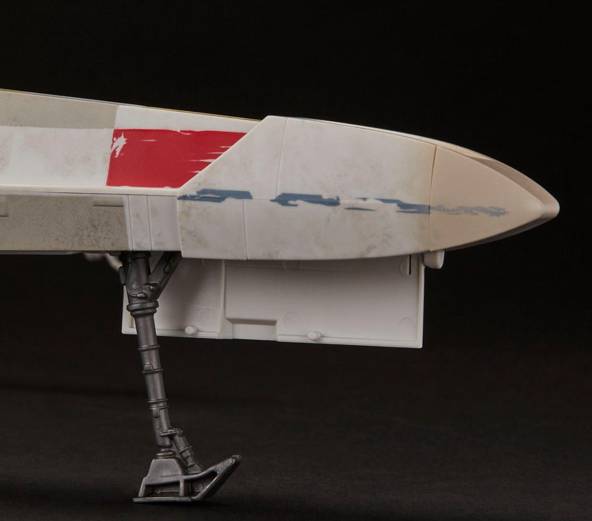 Close-up of weathered red and white X-Wing fighter landing gear with Kenner vintage style detailing