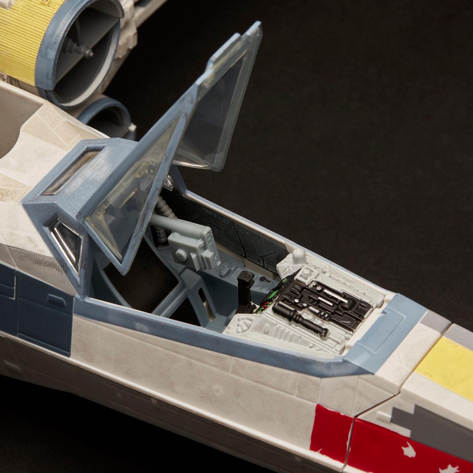 Close-up of vintage Kenner Star Wars X-Wing cockpit with open canopy and detailed interior controls.