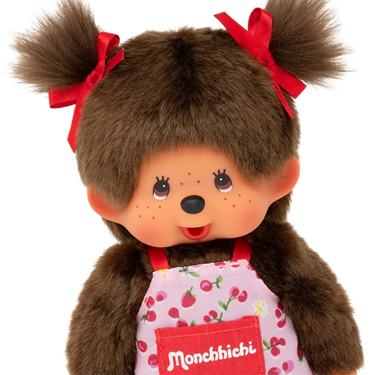 Sekiguchi Monchhichi girl plush monkey wearing pink flower apron with red hair bows close-up view