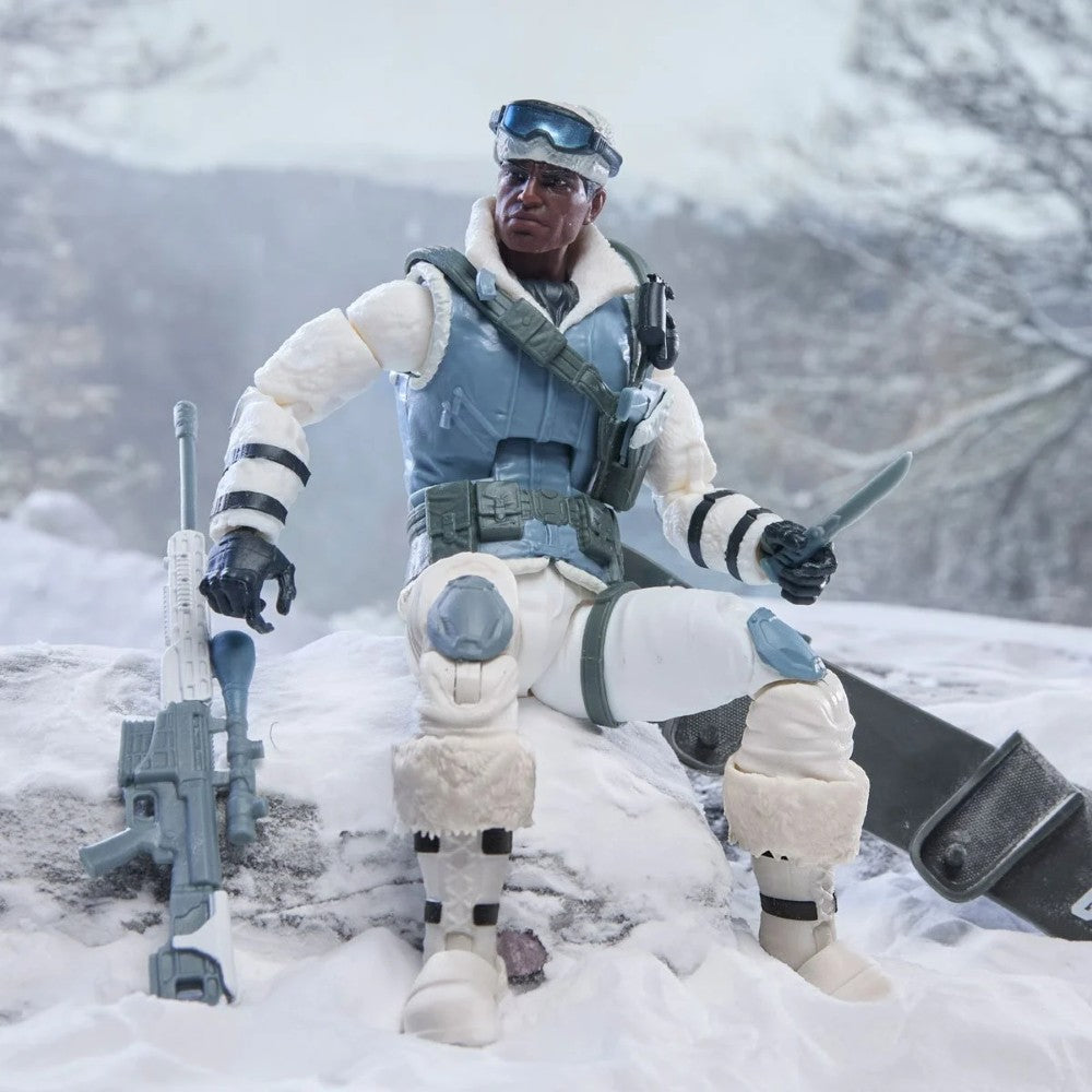 Winter-clad action figure kneeling in snow with a rifle and knife