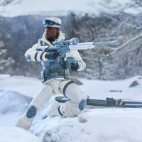 White-clad soldier action figure kneeling in snow with a scoped rifle