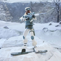 Action figure in winter gear holding a rifle while standing on skis in a snowy landscape