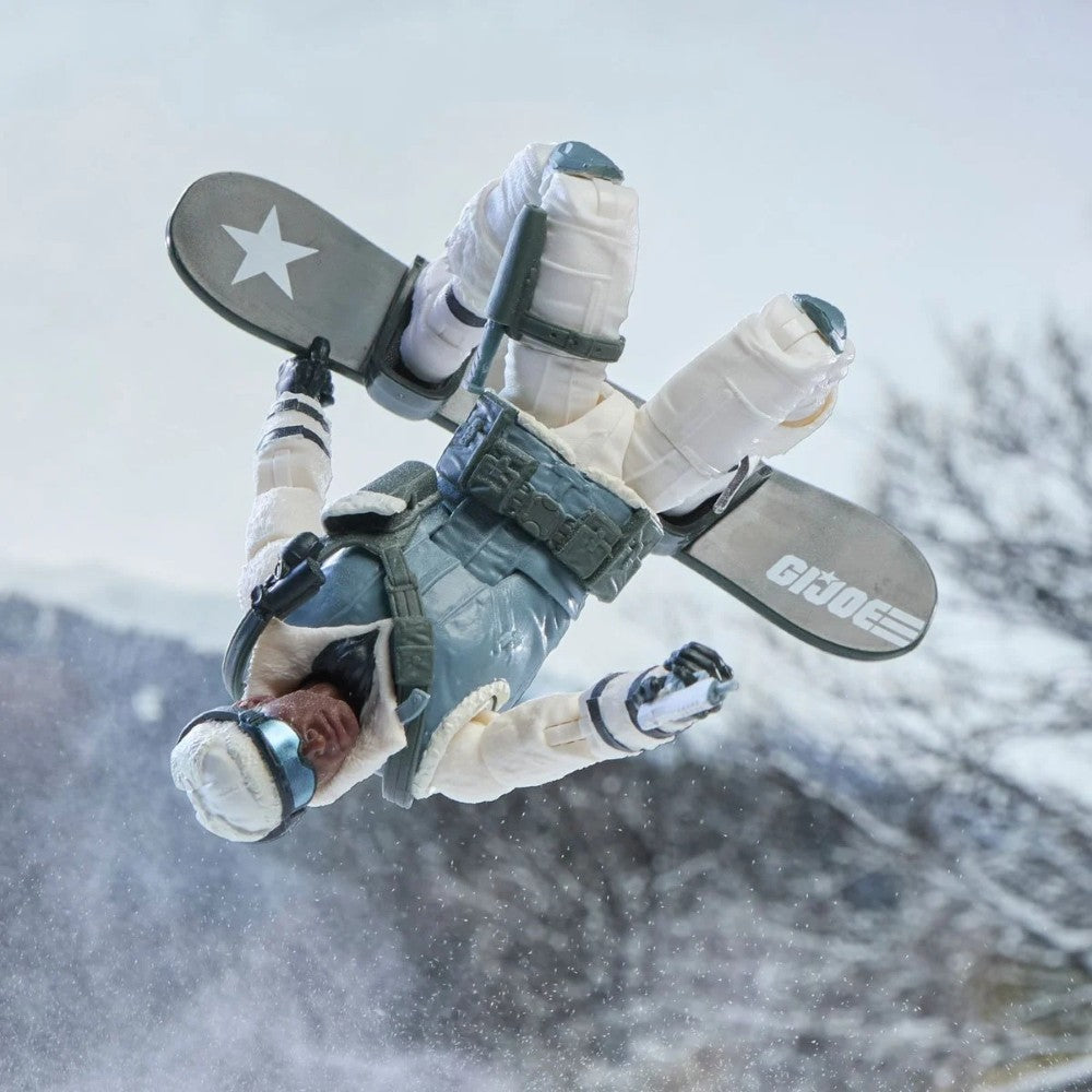 GI Joe figure in winter gear suspended upside down above snowy ground with skis marked GI Joe and a star